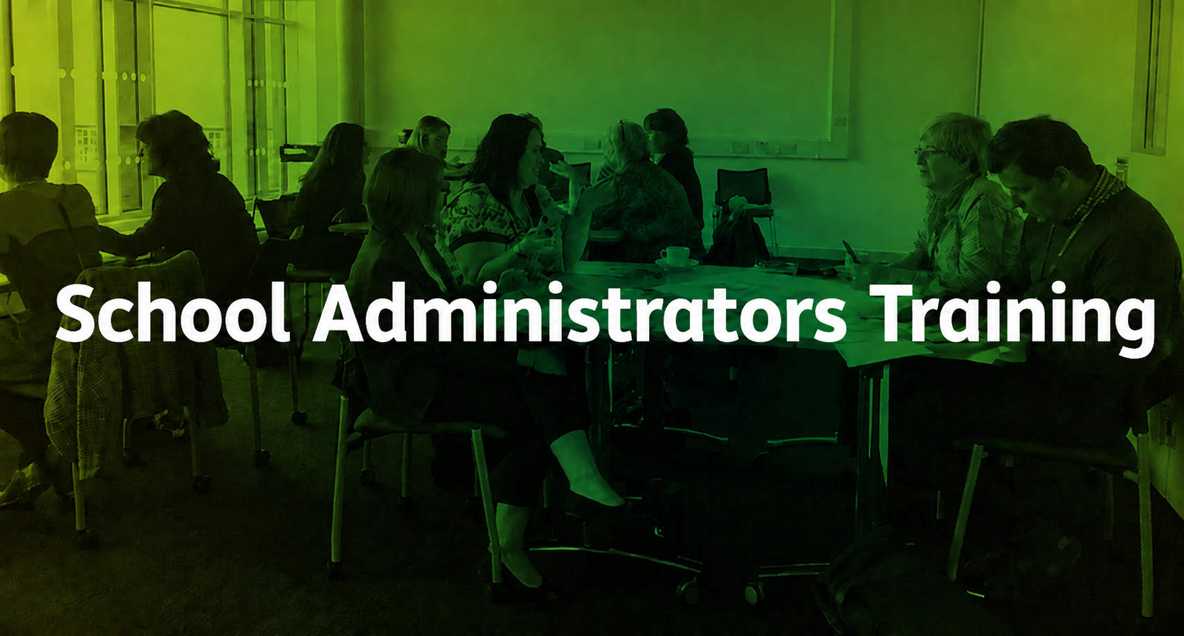 People sitting in groups discussing at tables in a classroom, overlaid with the text "School Administrators Training."